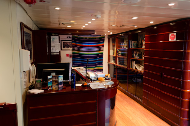 The ship's cozy Reception Lobby is located on Cabin Deck and features a small library of destination-specific books. Photo © 2014 Aaron Saunders