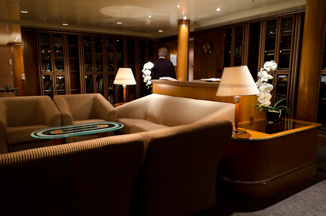 A guest browses through the extensive book collection in the Observation Lounge onboard Silver Shadow. Photo © 2014 Aaron Saunders